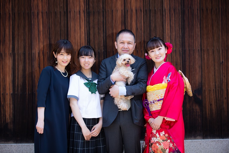 赤い振袖着たお嬢様とご家さまで記念撮影