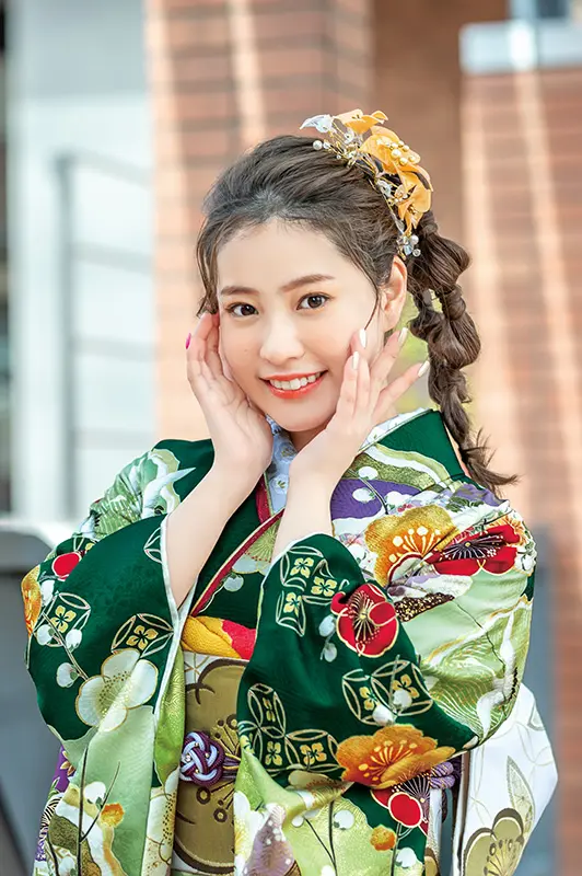 綺麗に髪の毛をセットして、鮮やかな緑の振袖とともに記念撮影