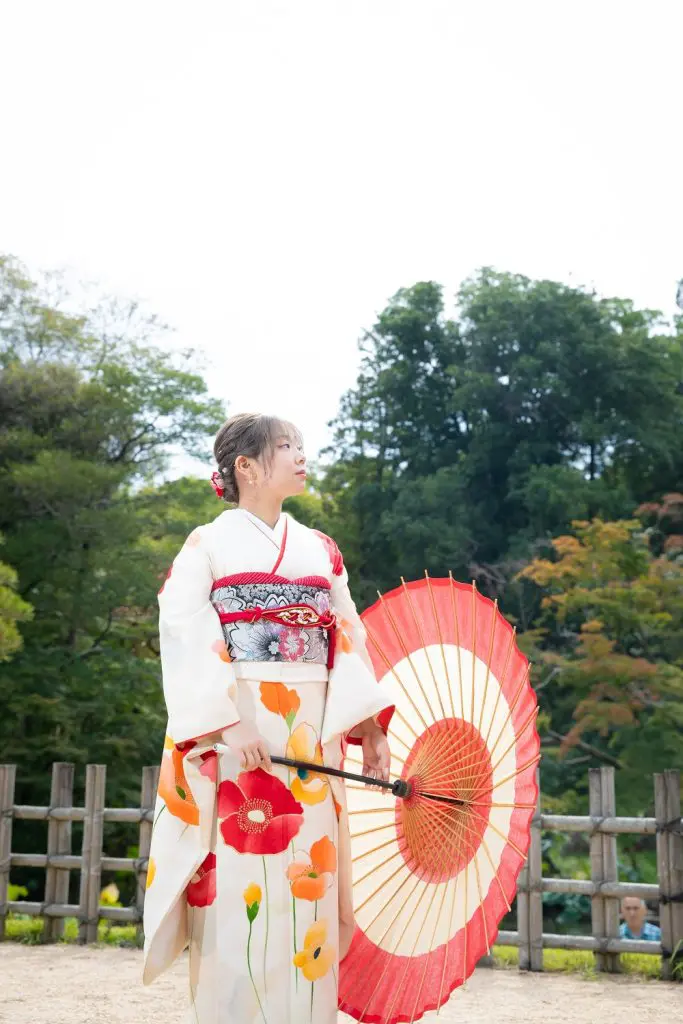 重衿と帯揚、帯締めを赤にして華やかさと統一感を出している 白の振袖をきた女性