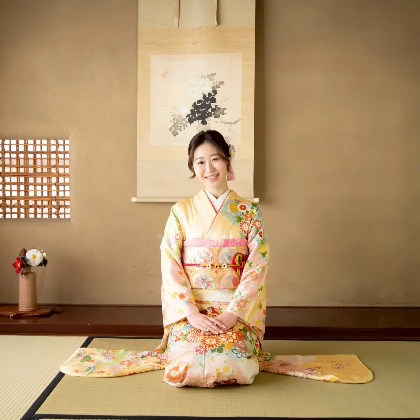 クリーム色の振袖を着て座っている女性