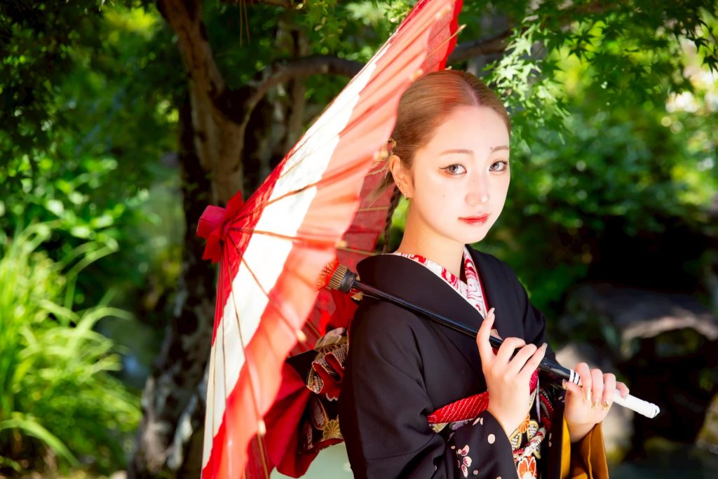 傘を持って黒い振袖を着た女性