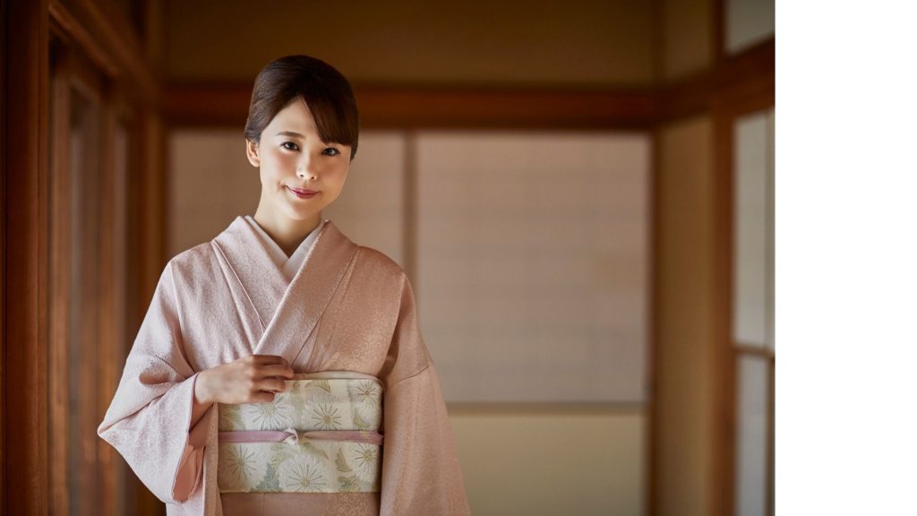 薄ピンクの色無地を着た女性