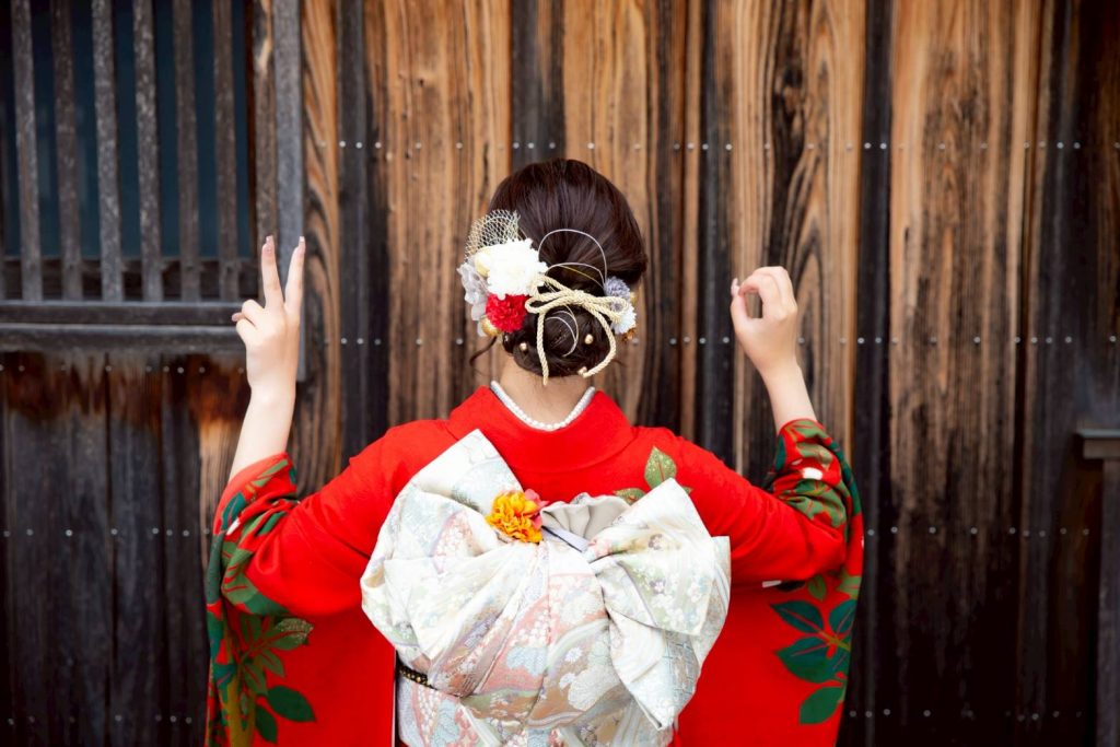赤い振袖を着て二十歳ポーズをした女性