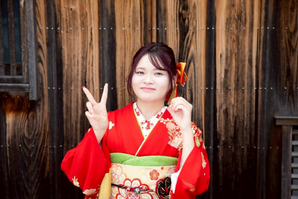 赤い振袖を着て二十歳ポーズをする女性