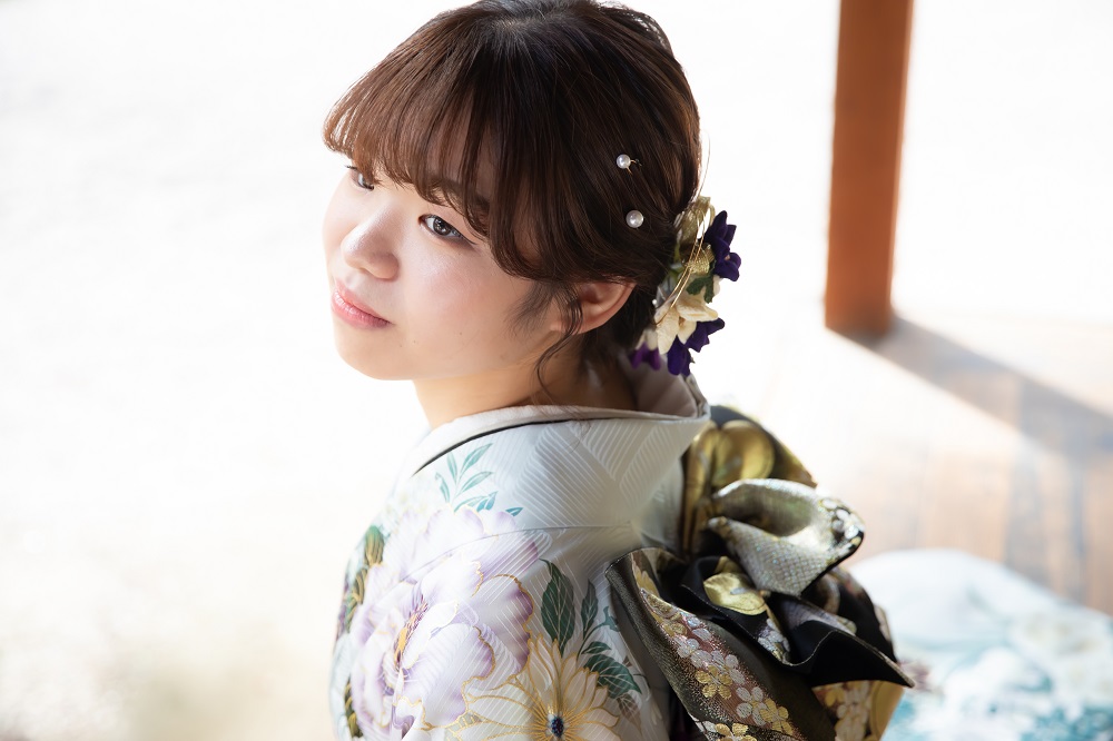 大きな花柄の白い振袖を着た女性