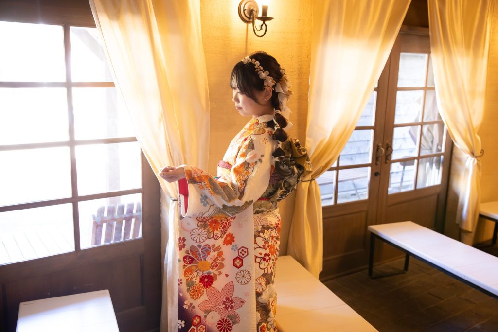 窓辺に立つ白い振袖姿の女性