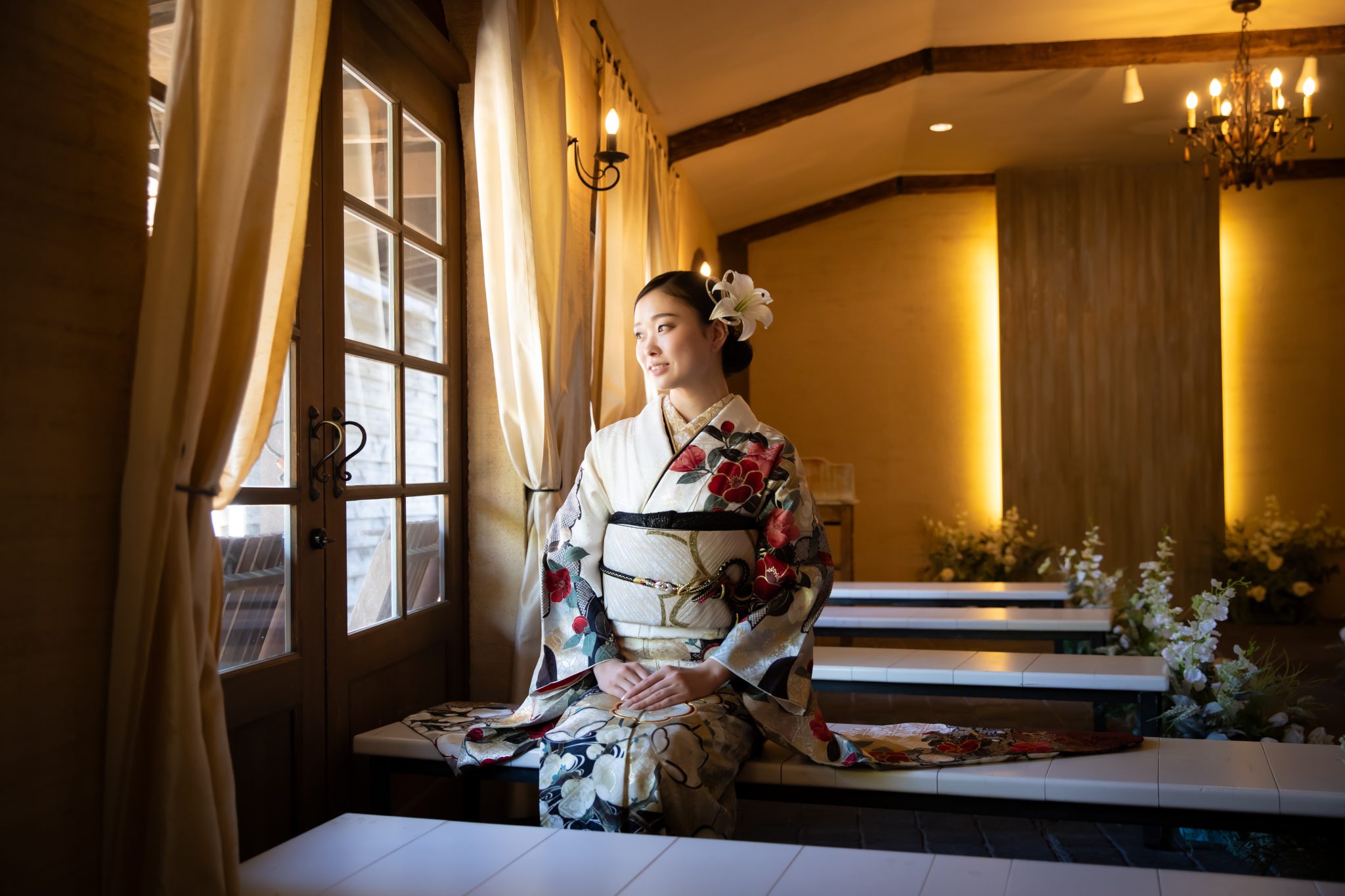 窓辺に座る白い振袖姿の女性