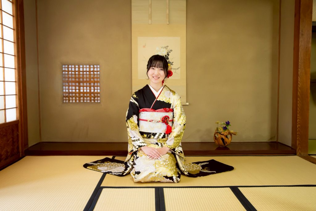 黒と金色の振袖を着た女性