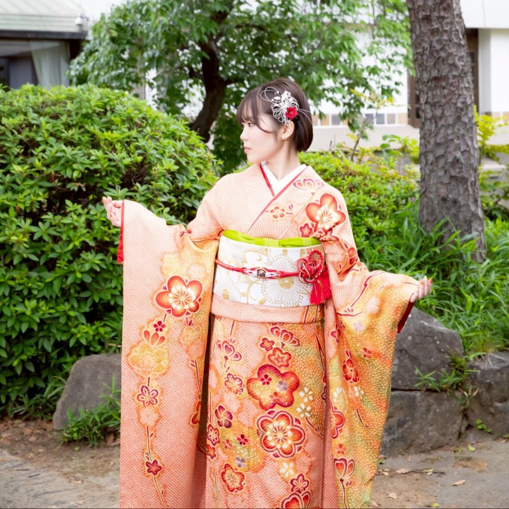 絞りのオレンジ色のママ振袖を着た女性