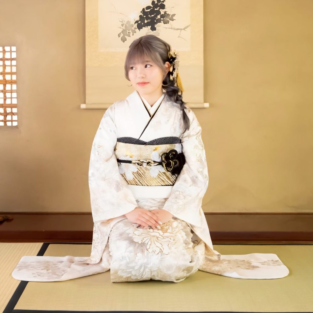 白の振袖を着て座っている女性